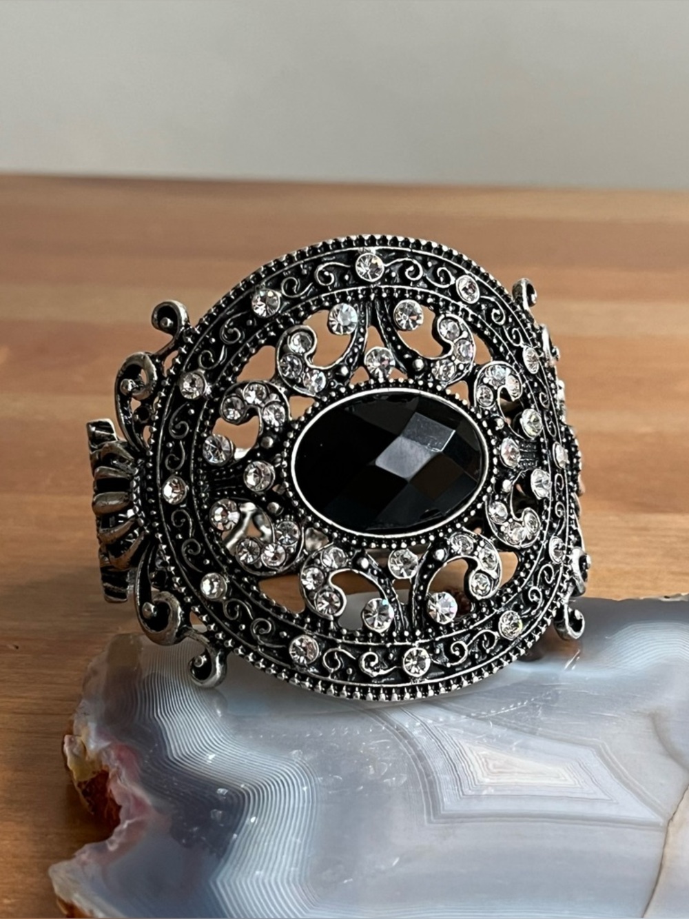 Vintage-style hinged cuff bracelet featuring a large black center stone jewelry
